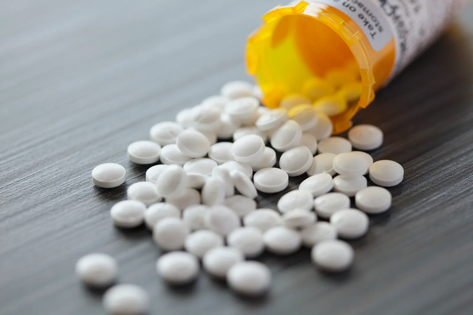 Prescription medication bottles arranged on a pharmacy shelf